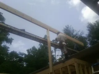 Carpenter setting a ridge beam over a new addition frame — Ice Dam Removal by Roofing Brothers in Malibu